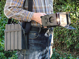 Mobile video lighting unit shown being hand-held, with optional mobile battery pack on a shoulder strap.